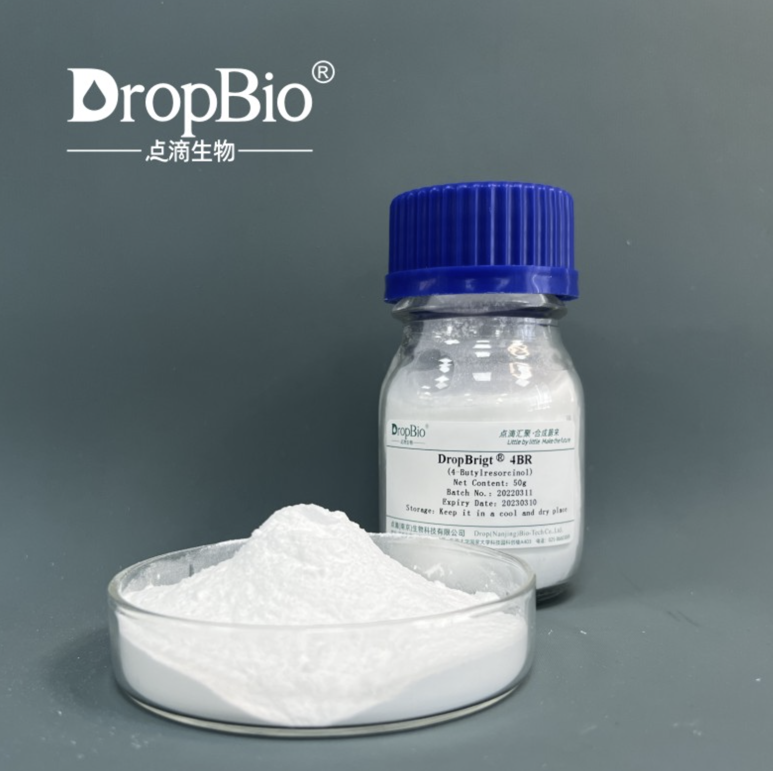 Bottle of DropBio product with 4-butylresorcinol powder in a beaker on a gray background